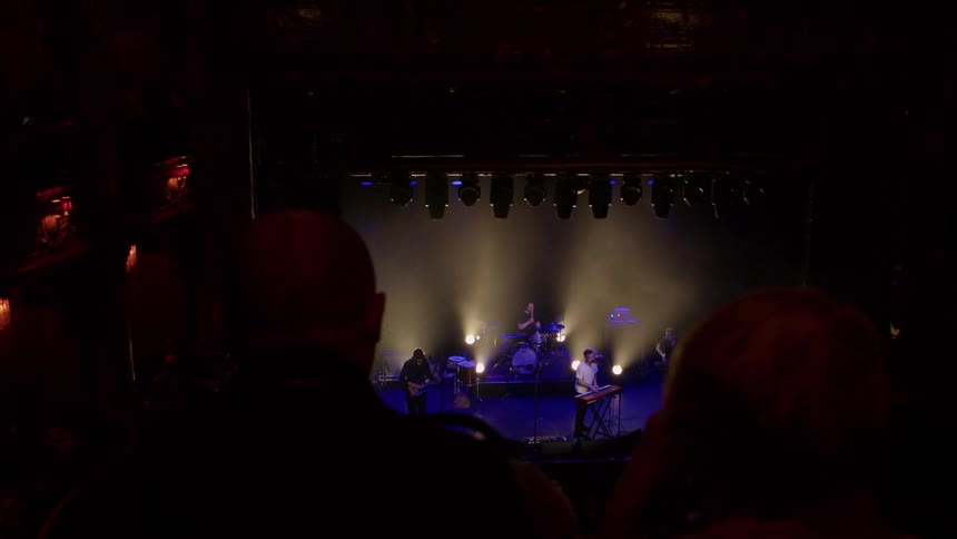 A rock band performing a show for an audience on a stage