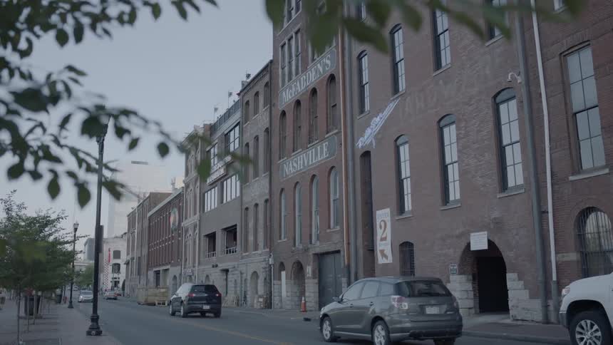 Cars driving past a brick building