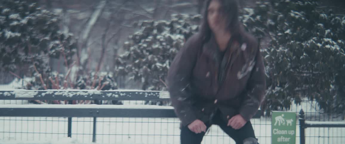Cold and dejected man getting up from a bench in a park on a snowy day