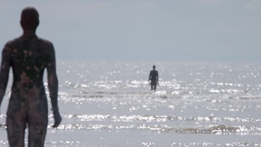 People are standing in the water covered with mud