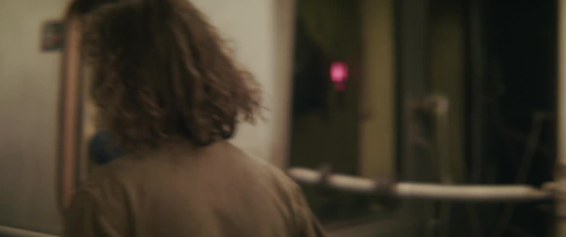 Back of a person getting on the train in a subway at night