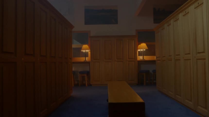 Dim lights glow in a locker-room lined with lockers