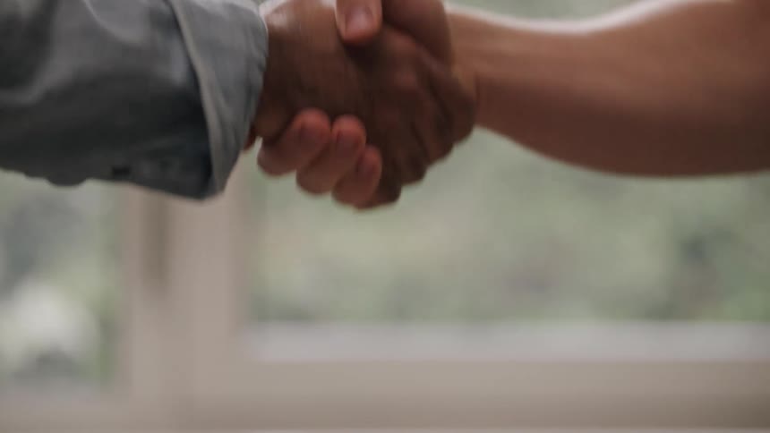 Two men shake hands