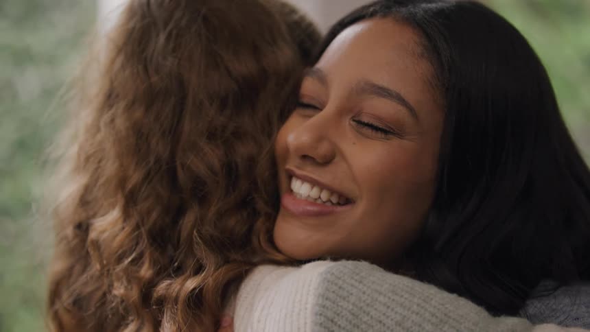 Two female friends are hugging and happy to see each other