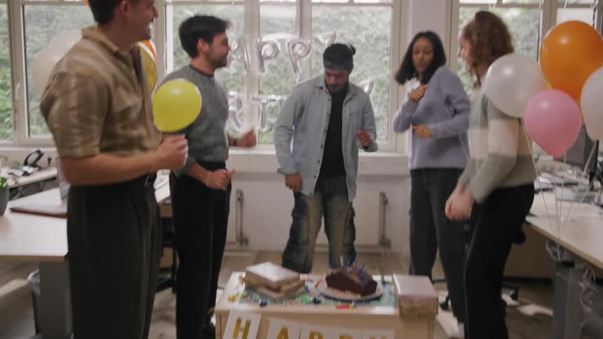 Friends in a corporate office celebrating a birthday