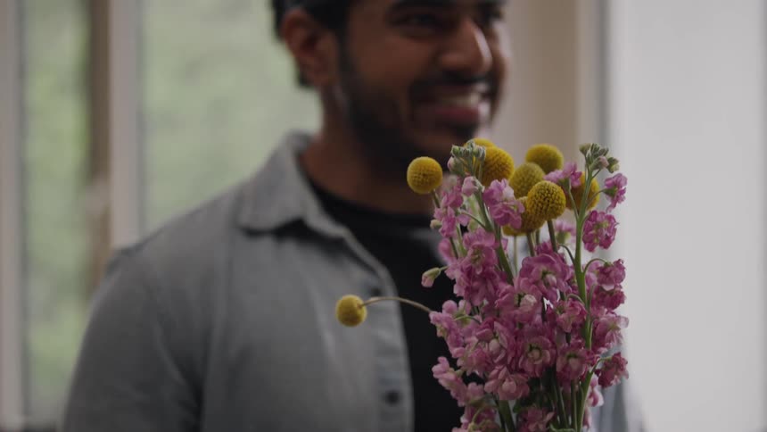 Cheerful man holding a bouquet of flowers