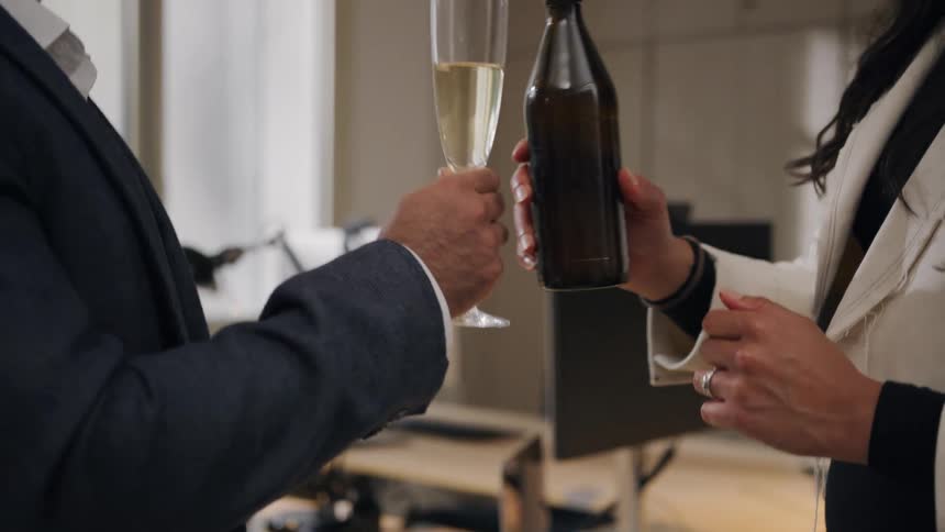 A man and woman toast and have a drink