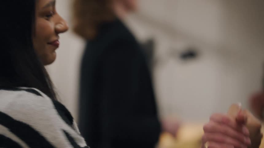 A young woman talks and smiles at a man as they shake hands