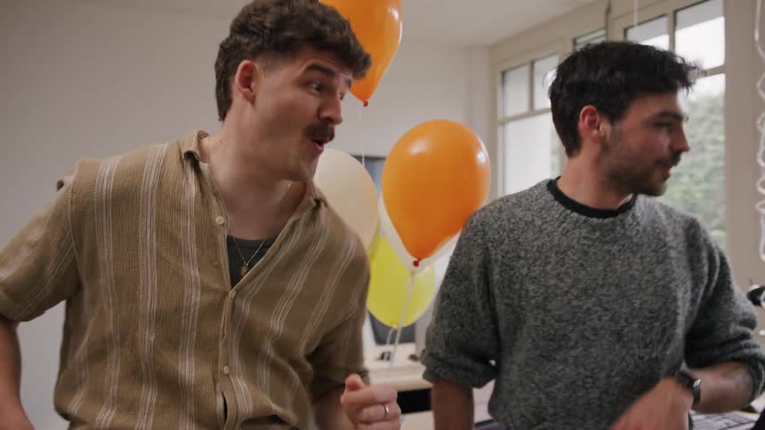 Workers are dancing in the office at a birthday party