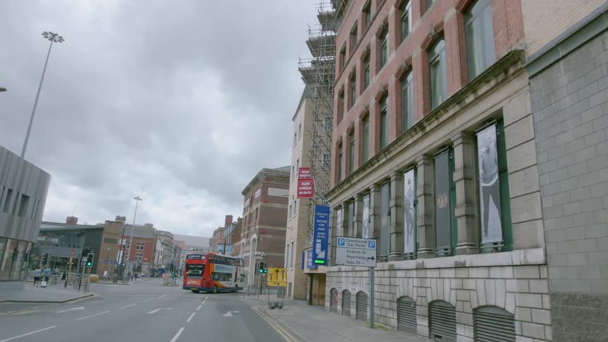 A bus and pedestrians travel down a city street