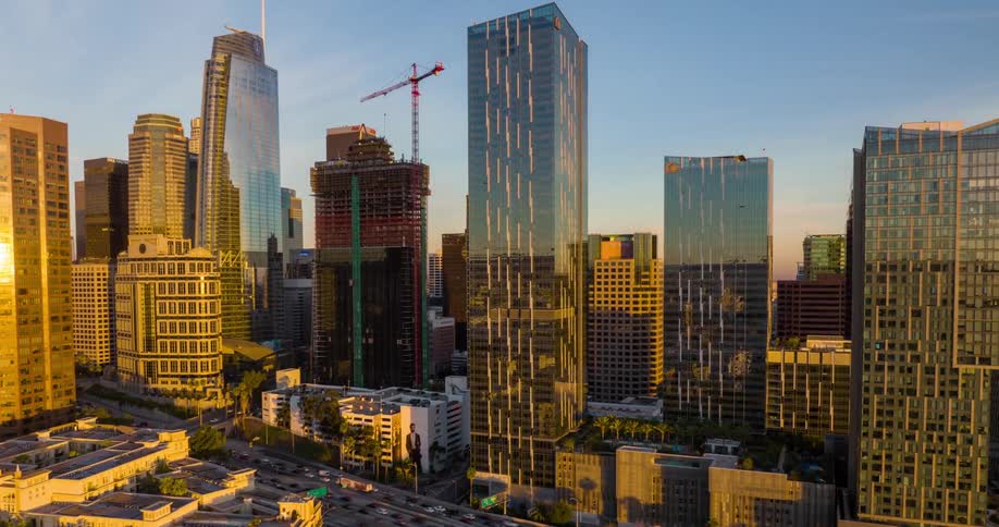 Aerial view of a downtown Los Angeles cityscape with modern highrise buildings at sunset