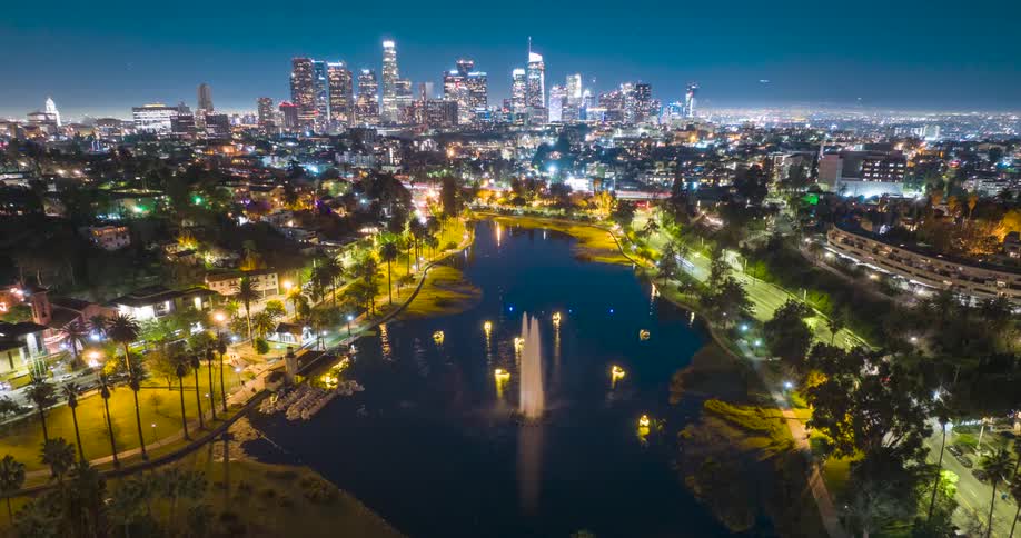 An aerial timelapse captures small boats move around Echo Park Lake fountain in Los Angeles at night