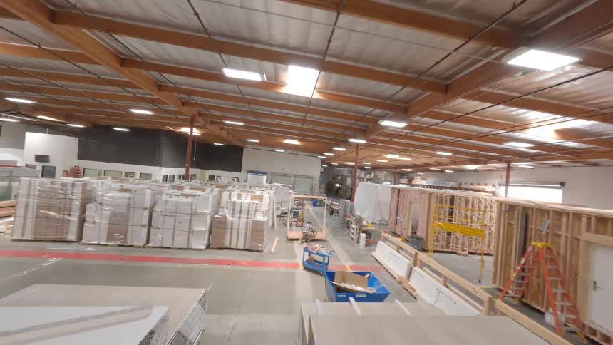 FPV drone flying inside a warehouse is full of wood and boxes