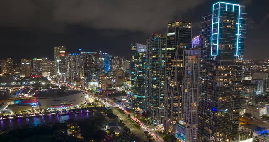 Cars are driving through downtown Miami with tall skyscrapers