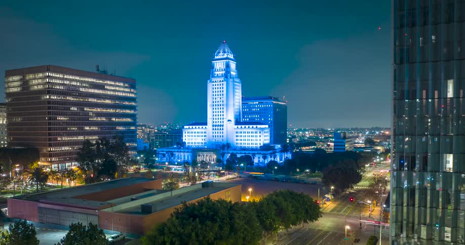 A blue illuminated Los Angeles City Hall building at night
