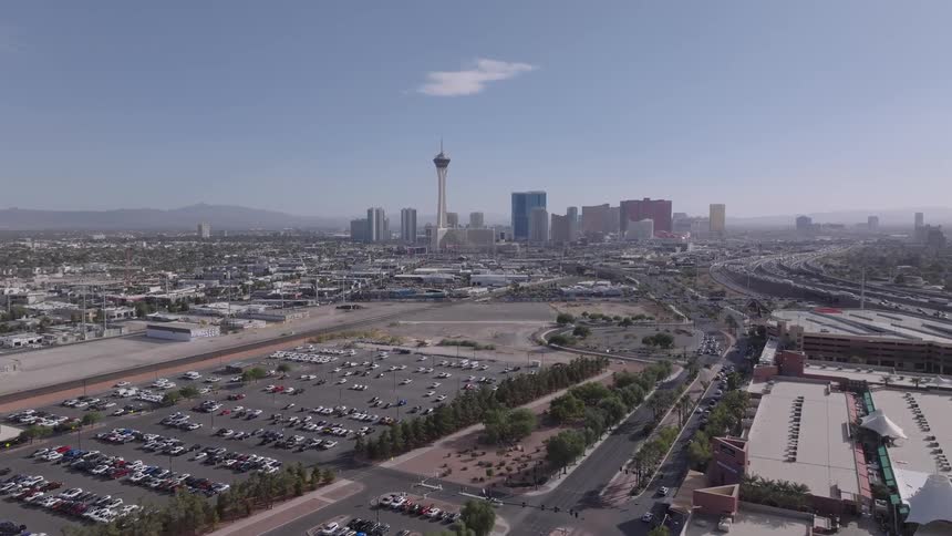 Aerial view of Las Vegas with parking lots city streets and desert mountains in the background
