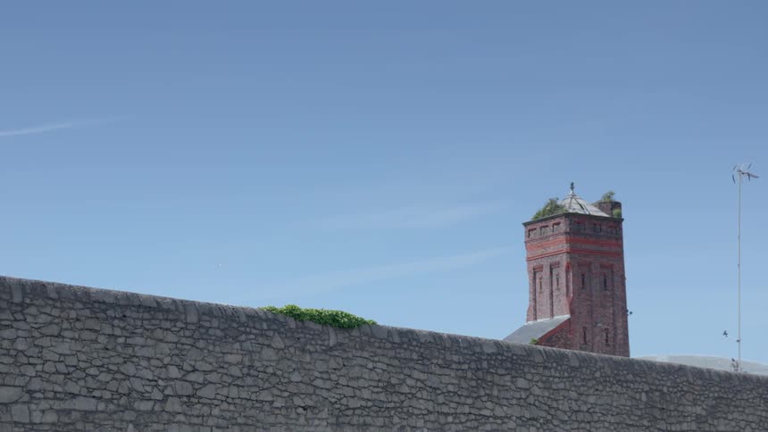 A stone wall in front of a tall building