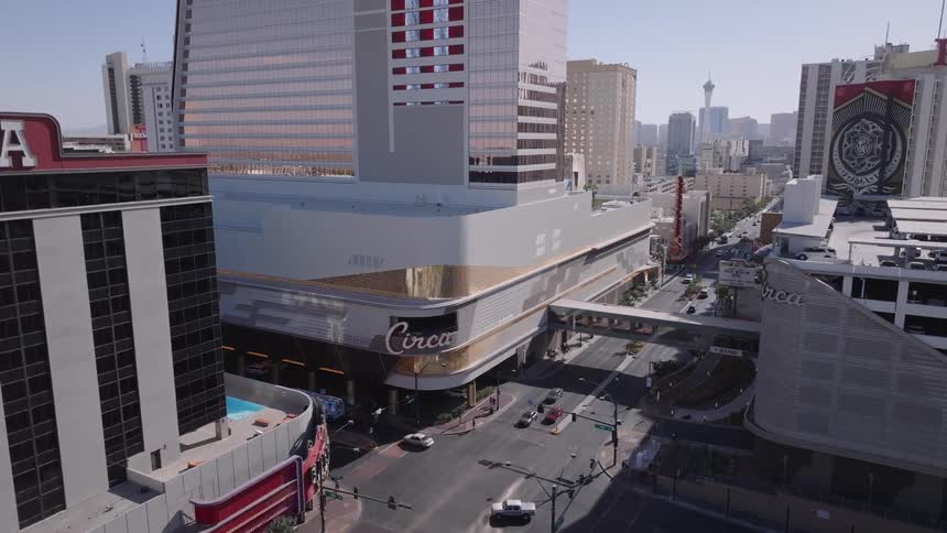 Aerial view of a downtown Las Vegas street surrounded by tall buildings and casinos under daylight