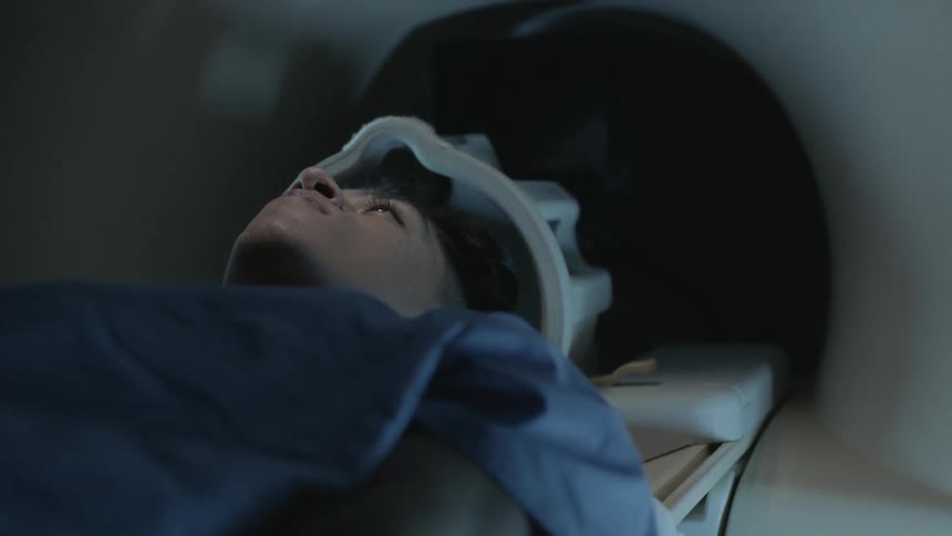A man lies on a table in an mri machine