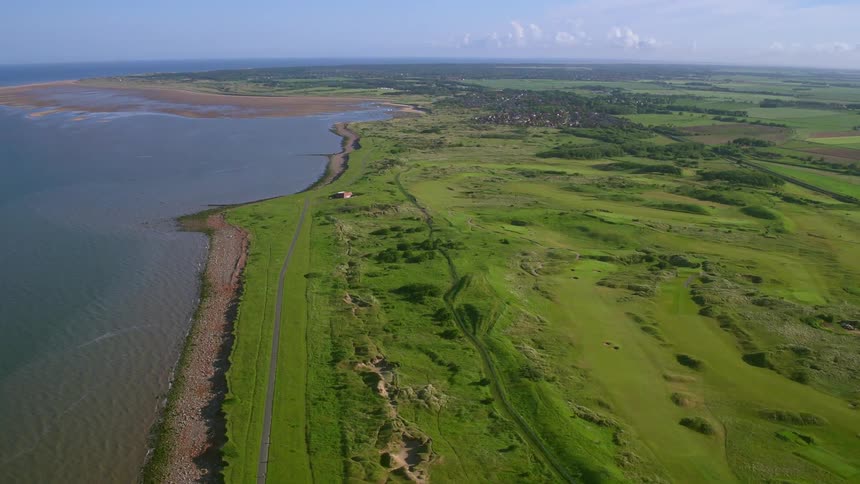 An overhead view of a grass area next to a body of water