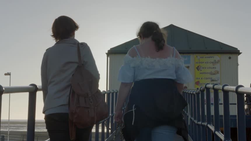 Two people walk up the ramp towards the shed