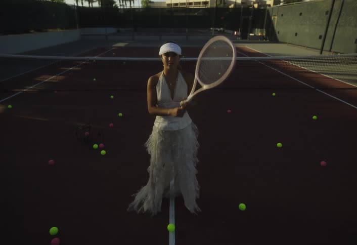 A woman poses with a tennis racket