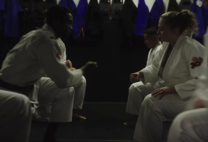 People wearing a judo gi shake hands