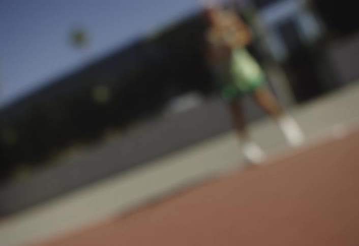 A woman hits the tennis ball back across the court