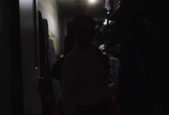 Woman walking down a hallway and turning on the light