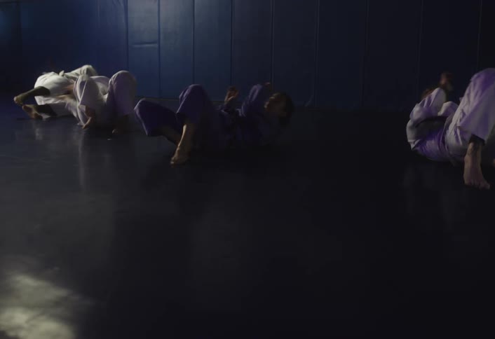 People are practicing judo by themselves in the gym