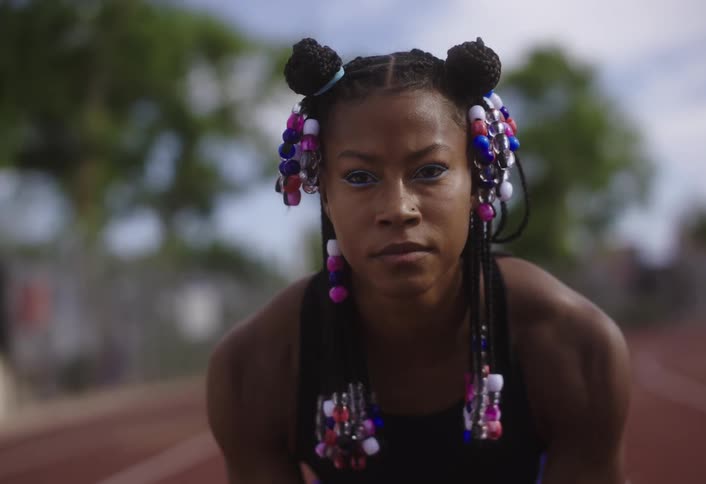 Woman on a running track with a determined expression