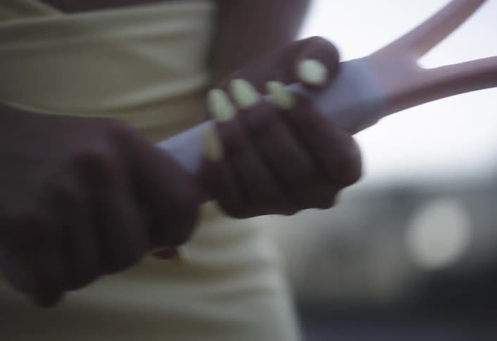 Close up of a female tennis players hands holding a tennis racket while playing outdoors during daytime