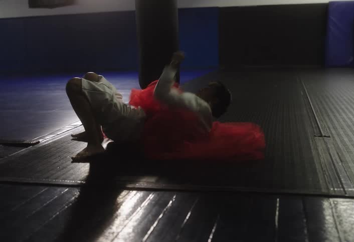 The woman is rolling on the mats practicing judo