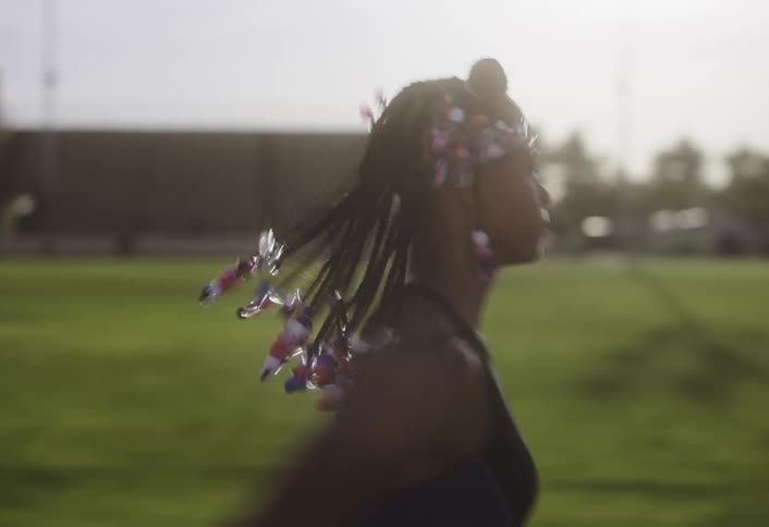Young girl runs joyfully across a sunny field
