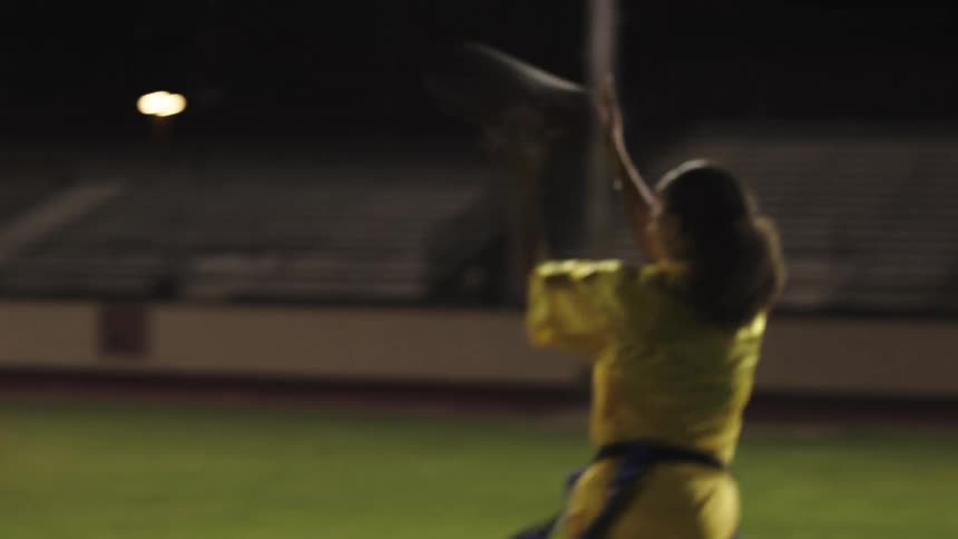 A woman runs and catches the football