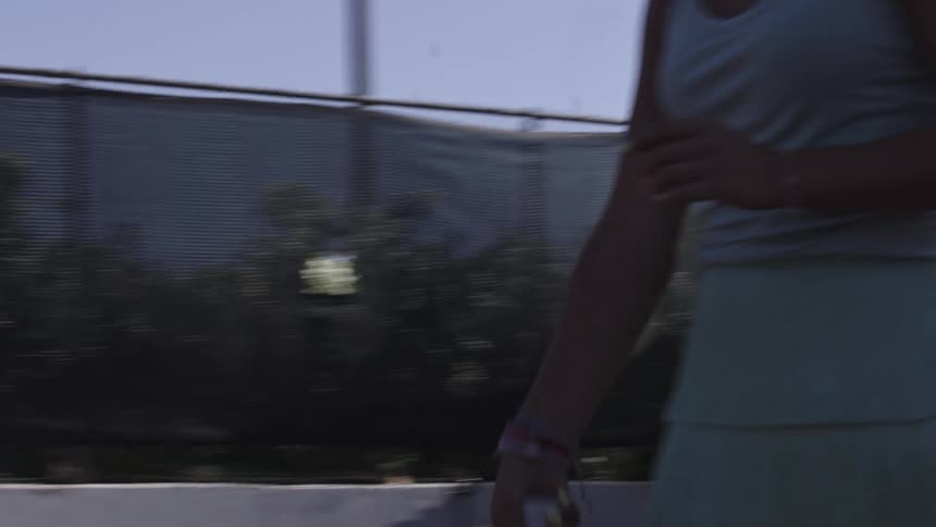 A woman tosses a racket up and down