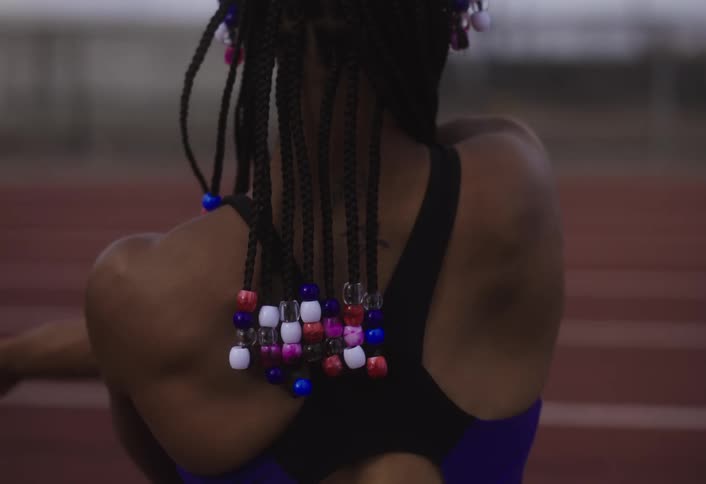 Woman stretching her arms on a running track