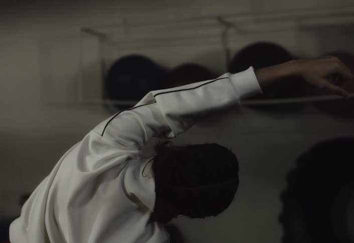 A woman enters a gym and starts stretching
