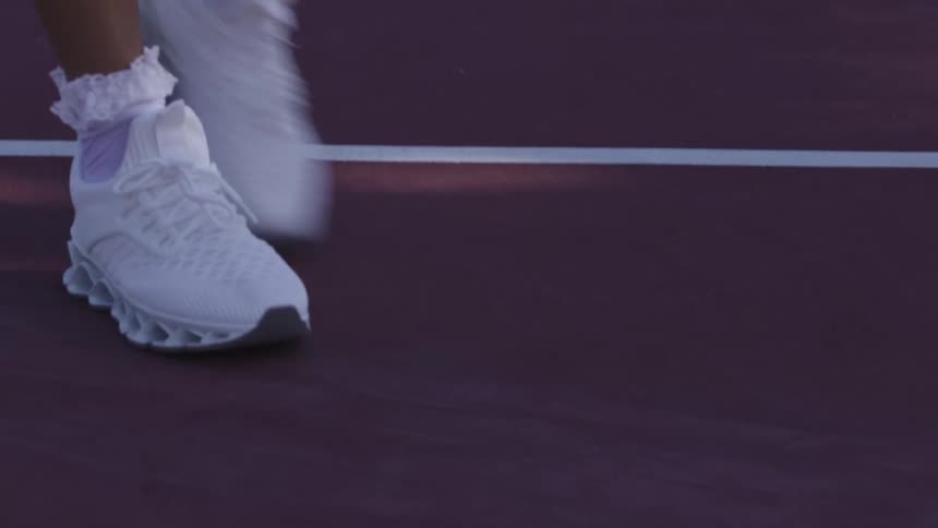 The woman walks on the court flipping her racket in her hand