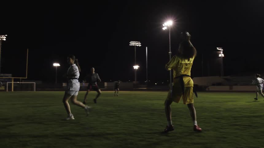 People are playing a game of flag football at night