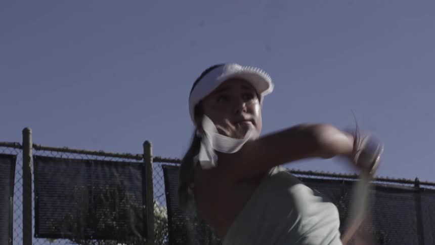 The woman is playing tennis on a sunny day