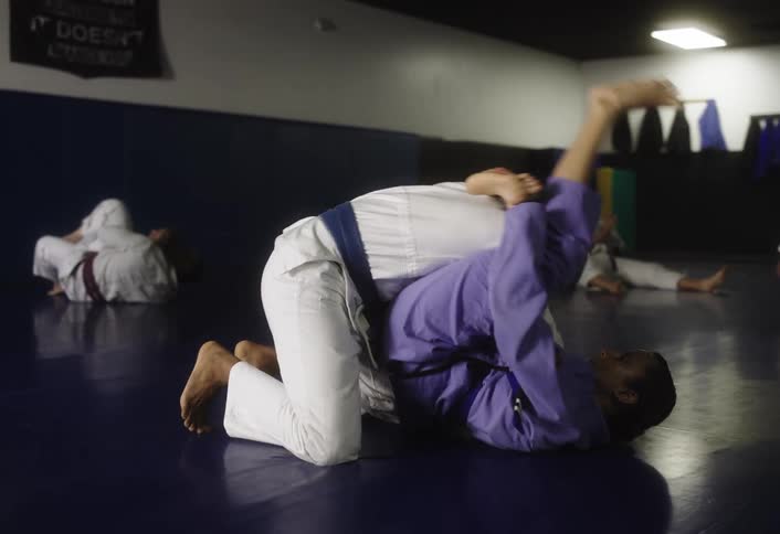 People in a gym training jiujitsu