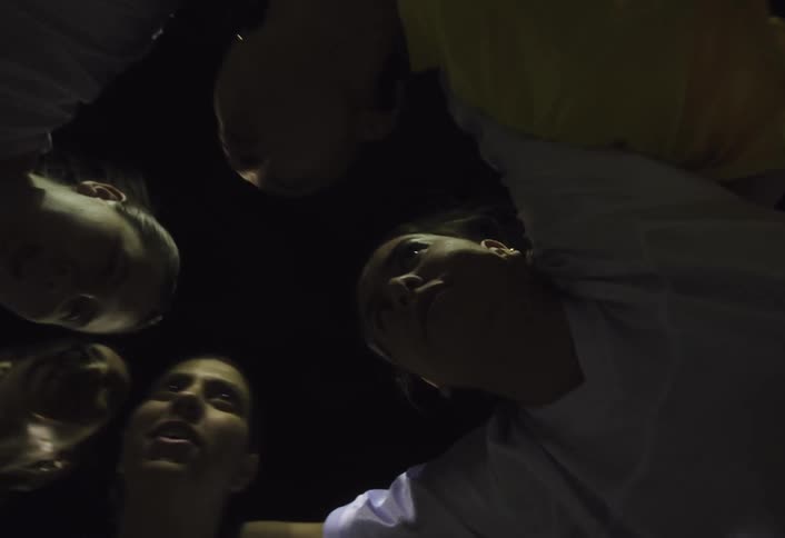 Women talk in a huddle at night