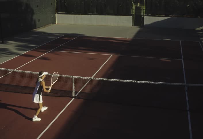 Woman practicing tennis on a secluded court
