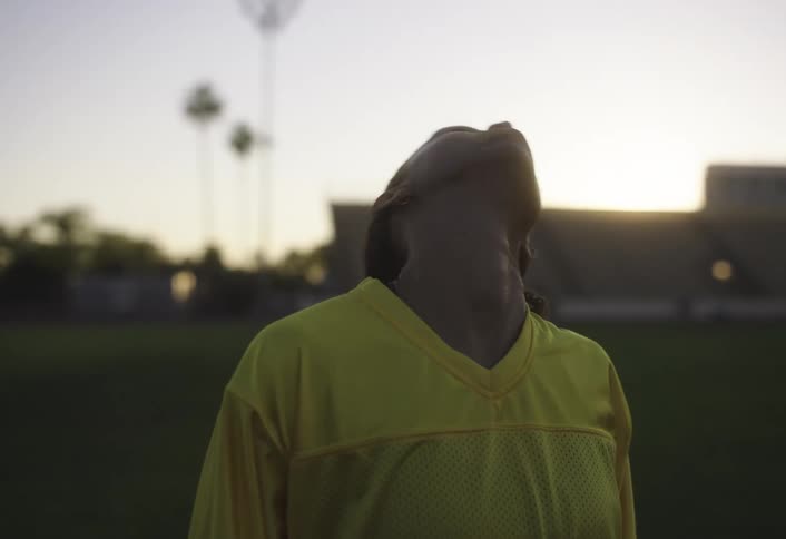 A woman stretches on a soccer field