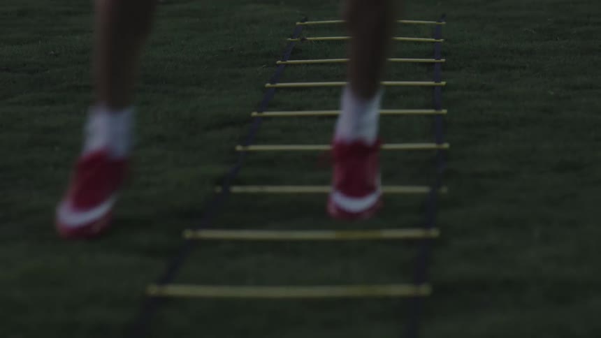 An athlete completes an exercise in the grass