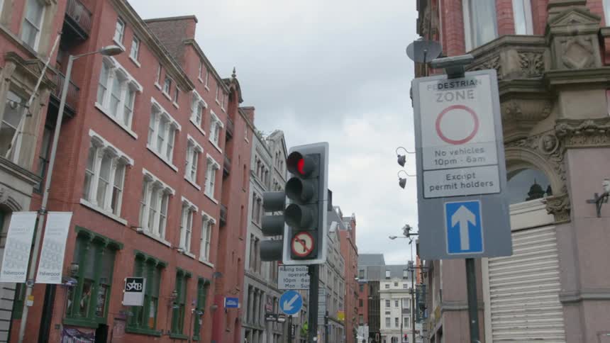 A car travels down a narrow city street