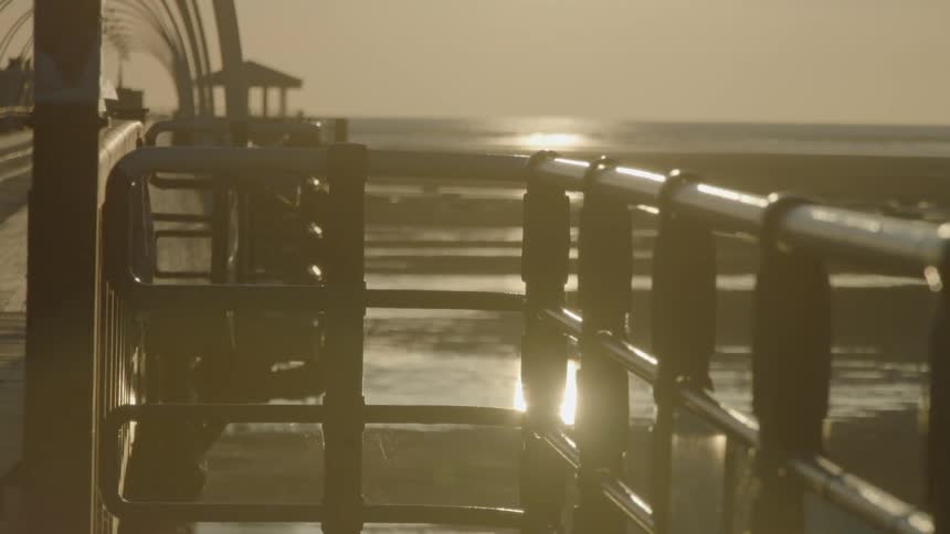 A rail near a pier at low tide