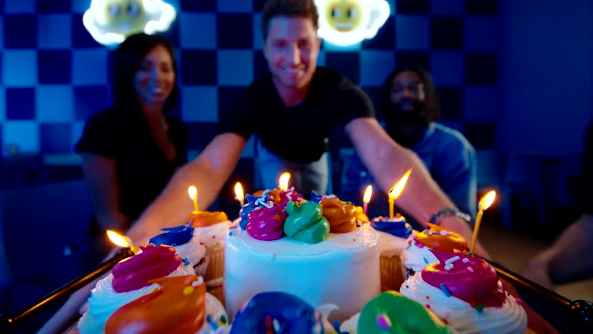 Friends celebrate a birthday with fun and laughter in a neonlit arcade