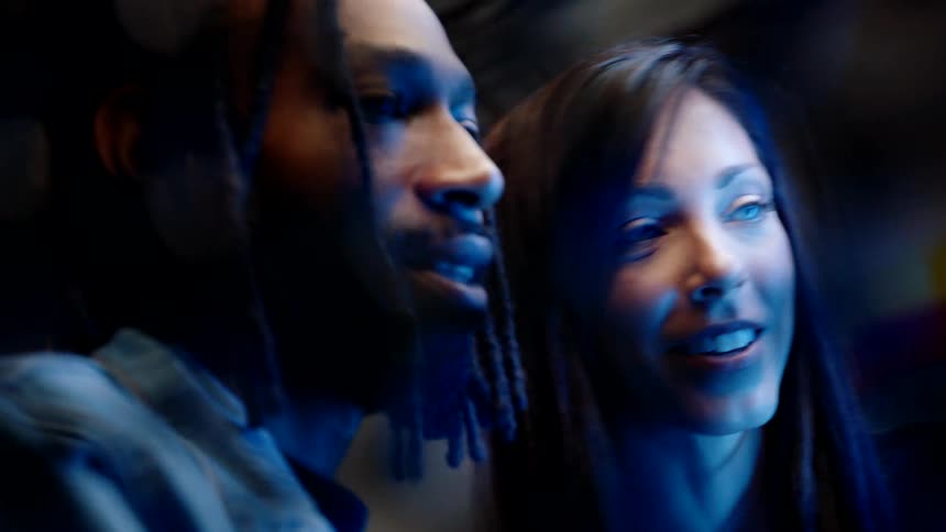 A man and woman watching something happily